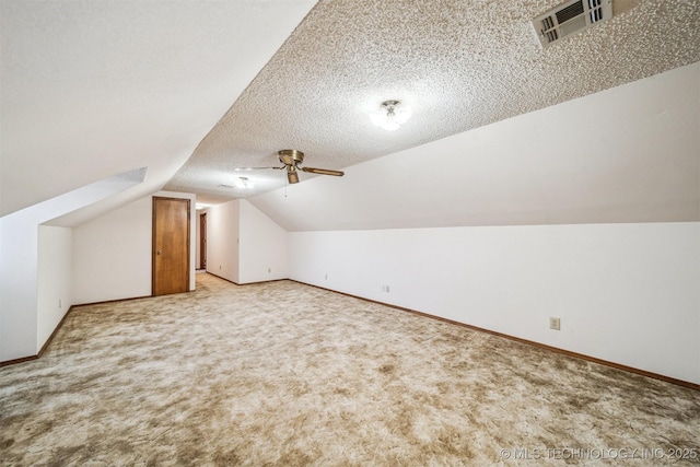 bonus room featuring ceiling fan, lofted ceiling, light colored carpet, and a textured ceiling