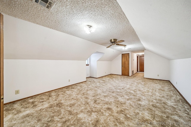 additional living space with lofted ceiling, ceiling fan, a textured ceiling, and carpet flooring