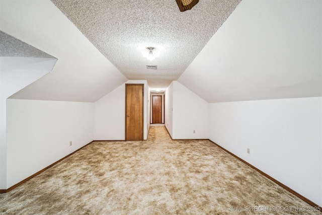 bonus room featuring light colored carpet, lofted ceiling, and a textured ceiling