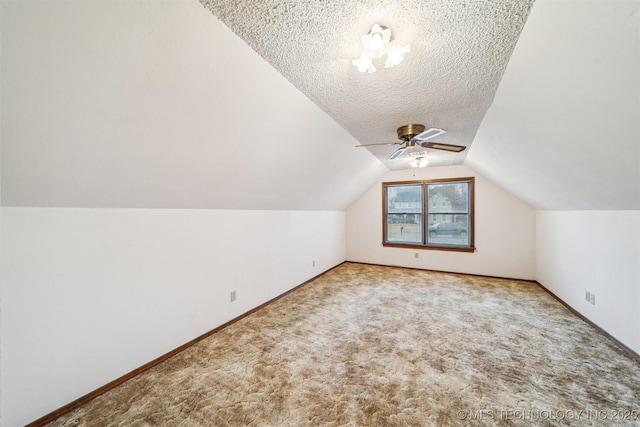 bonus room with ceiling fan, vaulted ceiling, a textured ceiling, and carpet