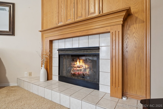 details with a tiled fireplace and carpet