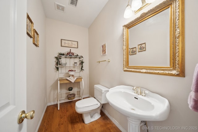 bathroom with wood-type flooring, sink, and toilet