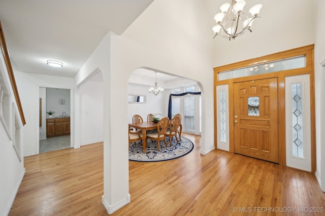 8402 N 100th E Ave, Owasso, OK 74055 - entryway featuring a chandelier, arched walkways, and light wood-type flooring