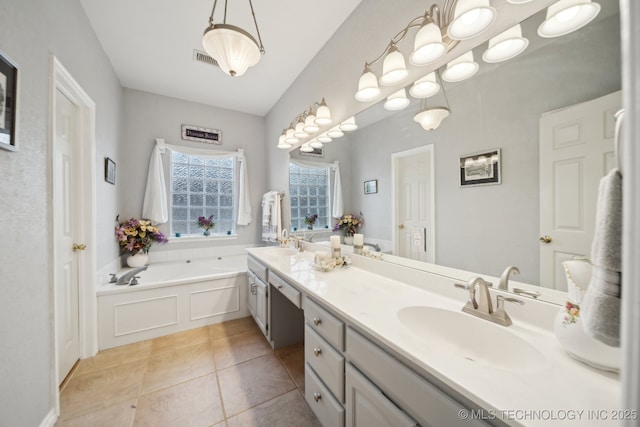 bathroom with tile patterned flooring, vanity, lofted ceiling, and a bathtub