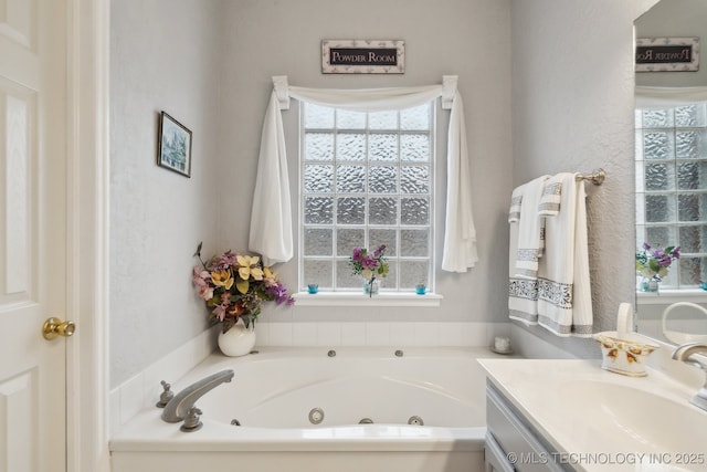 bathroom with vanity, a healthy amount of sunlight, and a washtub