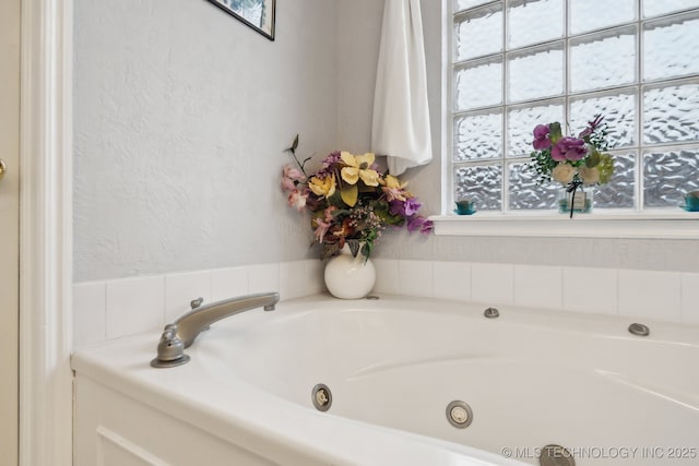 bathroom with a bath and plenty of natural light