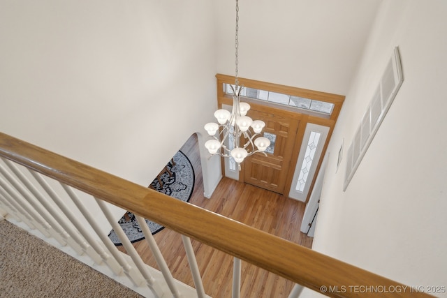 foyer with hardwood / wood-style flooring, a high ceiling, and a chandelier