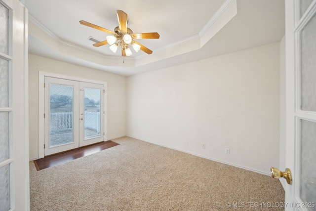 carpeted empty room with french doors, crown molding, ceiling fan, and a tray ceiling