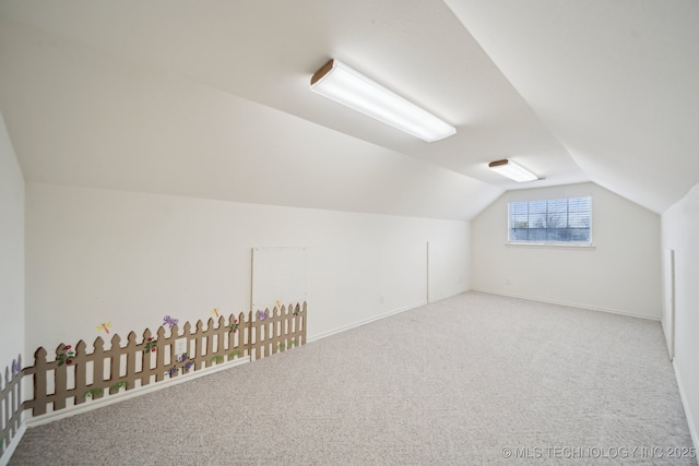 bonus room with vaulted ceiling and carpet floors