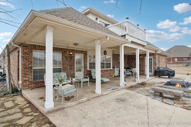 view of patio with a balcony, a grill, and a fire pit