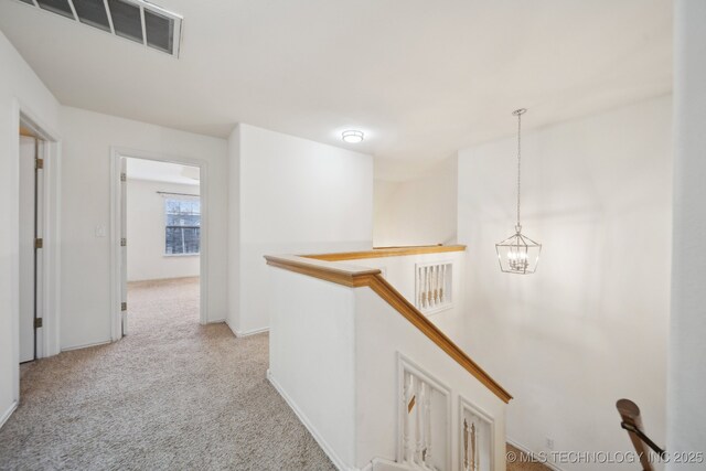 8402 N 100th E Ave, Owasso, OK 74055 - hallway featuring an upstairs landing, a chandelier, and light carpet