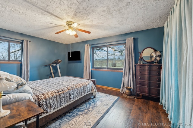 bedroom featuring ceiling fan, dark hardwood / wood-style flooring, and a textured ceiling