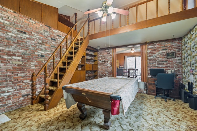 playroom with pool table, a high ceiling, brick wall, and a ceiling fan