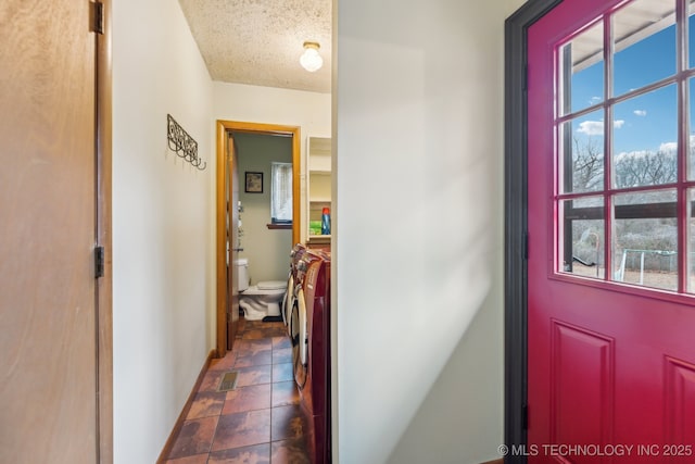 interior space with washing machine and dryer and a textured ceiling