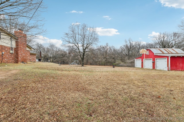 view of yard featuring a garage and an outdoor structure