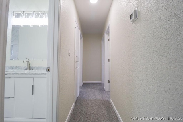 hallway with carpet floors and sink