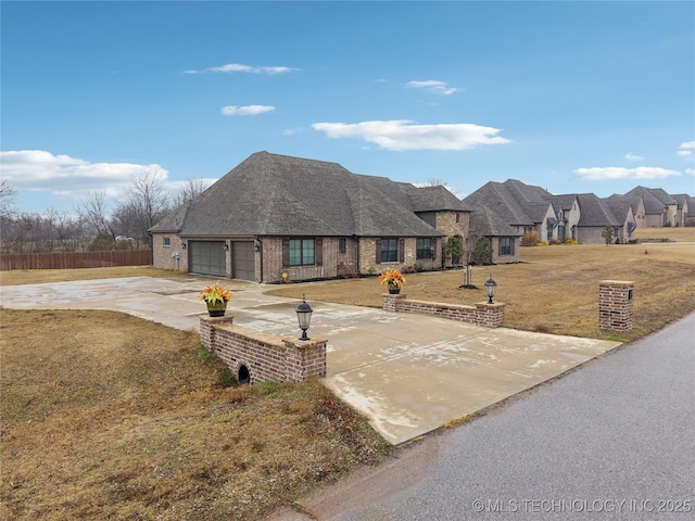 french provincial home featuring a garage and a front lawn