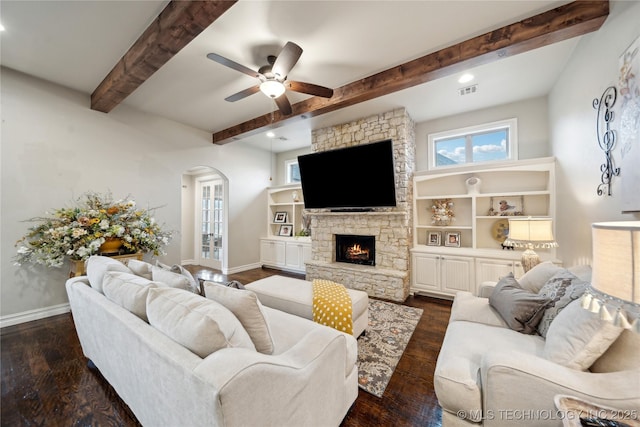 living room with ceiling fan, a fireplace, dark hardwood / wood-style floors, and beamed ceiling