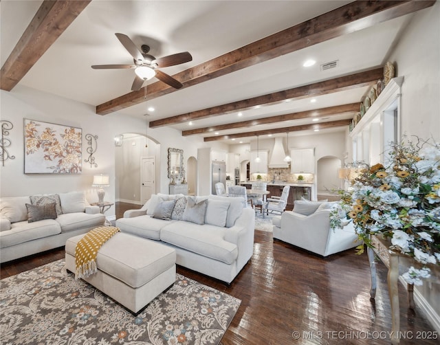 living room featuring beam ceiling, ceiling fan, and dark hardwood / wood-style flooring