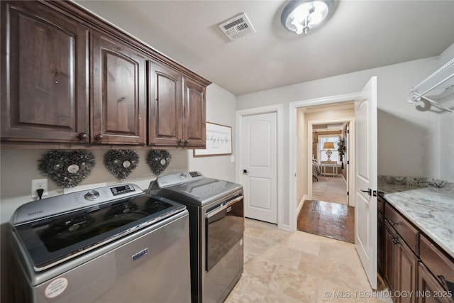 washroom featuring independent washer and dryer and cabinets