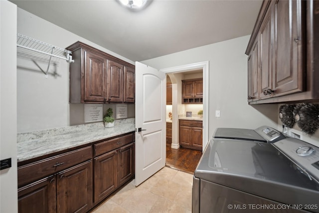 laundry area with cabinets, light tile patterned floors, and independent washer and dryer