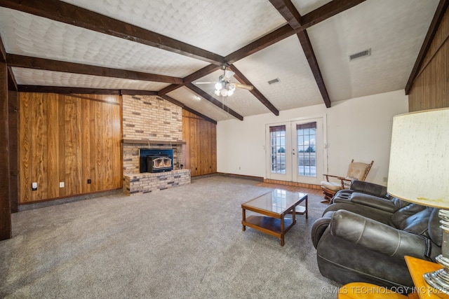 living room featuring french doors, vaulted ceiling with beams, wooden walls, carpet floors, and ceiling fan