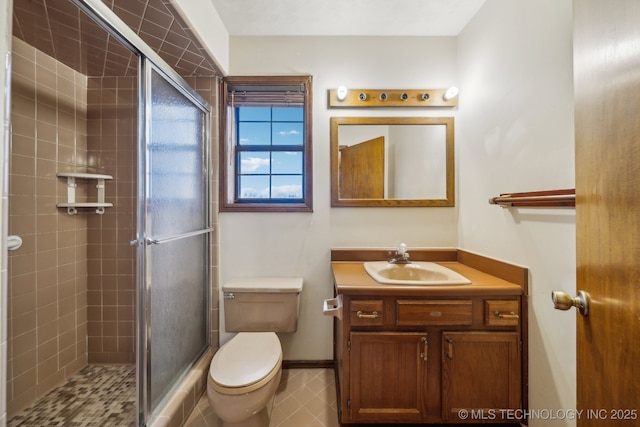 bathroom with vanity, toilet, and a shower with door