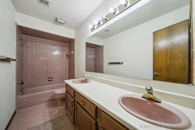 full bathroom featuring tiled shower / bath combo, vanity, tile patterned floors, and toilet