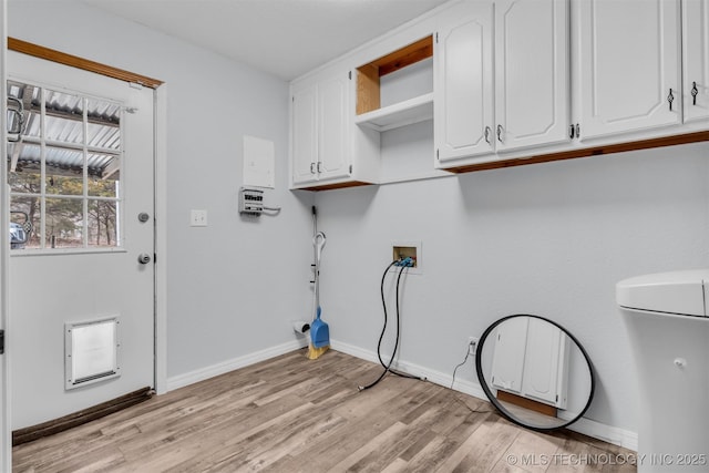 clothes washing area with cabinets, washer hookup, and light hardwood / wood-style floors