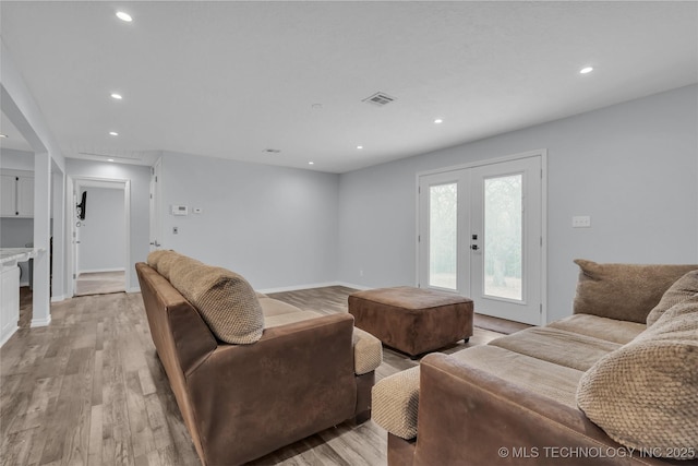 living room with french doors and light wood-type flooring