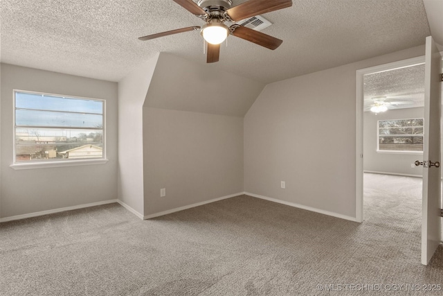 bonus room with lofted ceiling, ceiling fan, light colored carpet, and a textured ceiling