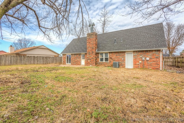 rear view of house with a yard and central AC unit