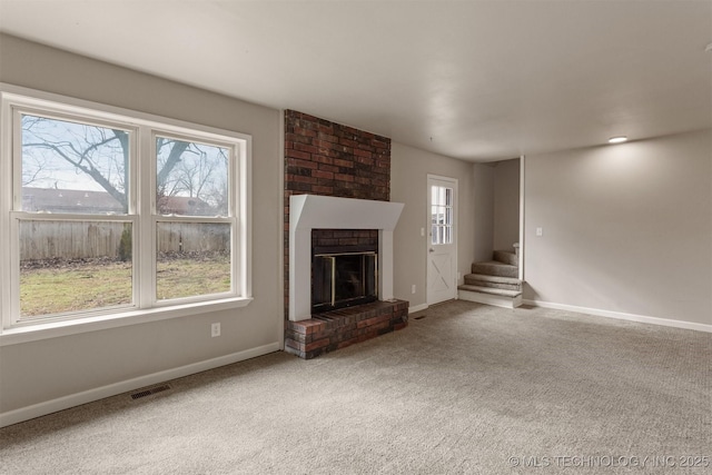 unfurnished living room with a fireplace and carpet flooring