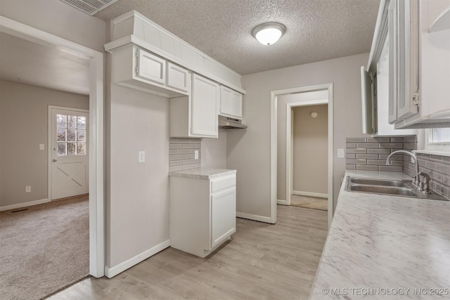 kitchen featuring white cabinetry, sink, and light hardwood / wood-style floors