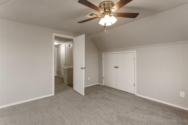 additional living space featuring light carpet, ceiling fan, vaulted ceiling, and a textured ceiling