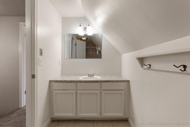 bathroom featuring lofted ceiling, tile patterned flooring, and vanity