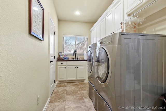 laundry room featuring cabinets, separate washer and dryer, and sink