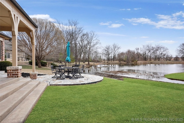 view of yard with a water view and a patio area