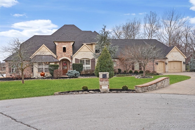 french provincial home with a garage and a front yard