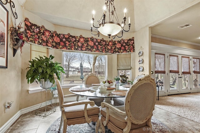 dining space featuring ornamental molding and an inviting chandelier