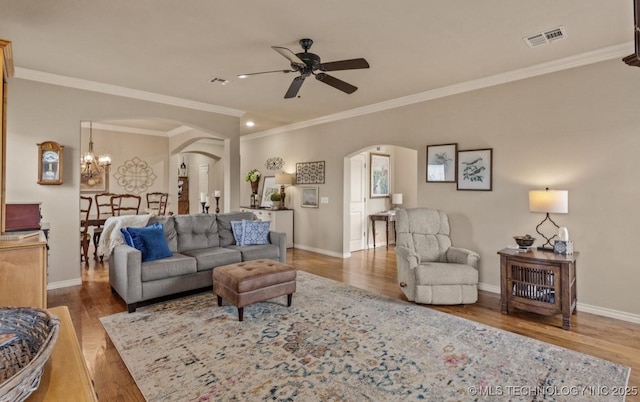 living room with crown molding, ceiling fan with notable chandelier, and light hardwood / wood-style flooring