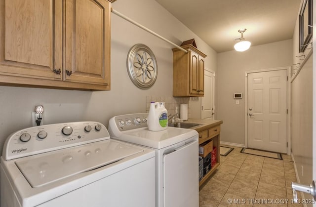 laundry room featuring cabinets, sink, washer and dryer, and light tile patterned floors