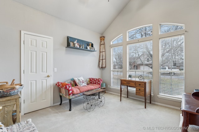 living area with light carpet and high vaulted ceiling