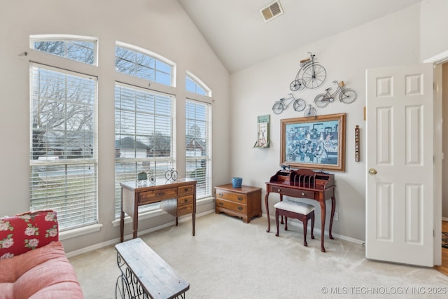 sitting room with light carpet and high vaulted ceiling