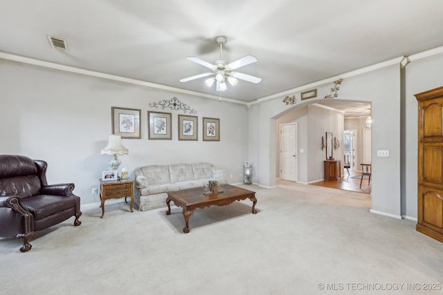 living room with ornamental molding, light colored carpet, and ceiling fan