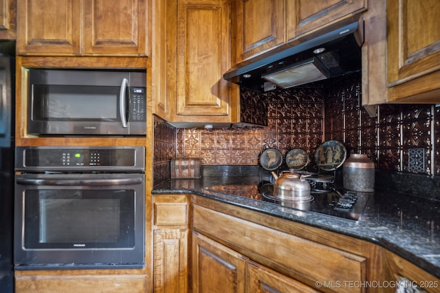 kitchen with extractor fan, backsplash, black appliances, and dark stone counters