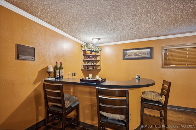 bar featuring ornamental molding and a textured ceiling