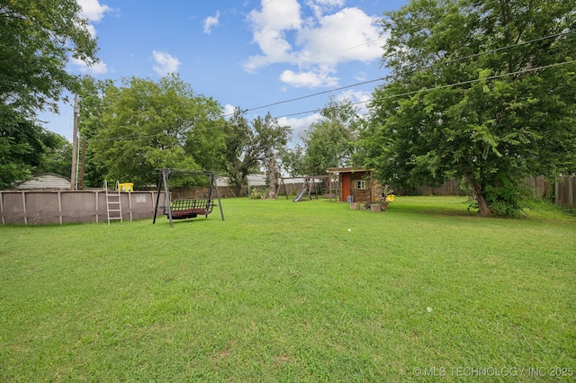 view of yard featuring a playground and a swimming pool