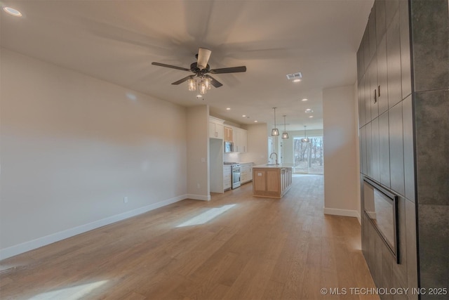 unfurnished living room with a fireplace, ceiling fan, and light wood-type flooring