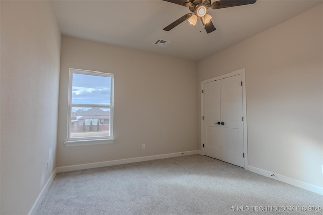 carpeted spare room with ceiling fan